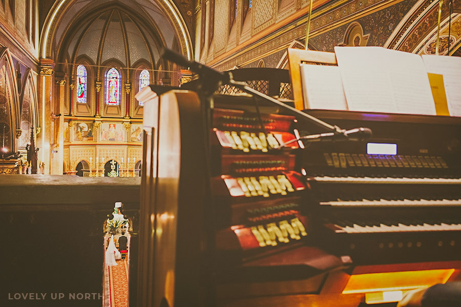 Yorkshire photographer capturing a couple as they get married in a church in the background, with an organ in the foreground