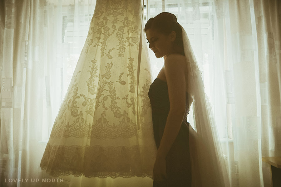 Yorkshire photographer capturing a delicate portrait of a bride to be and her dress against the light of a window
